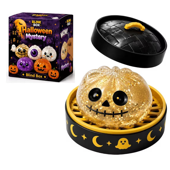 A Halloween Bun Squishy Toy from Okie Soft Play, featuring a glittery pumpkin with a skull face, sits in a yellow dish decorated with moon and ghost designs. The black lid rests nearby. The box, labeled “BLINK BOX Halloween Mystery Blind Box,” displays more of the filled TPR fidget characters.