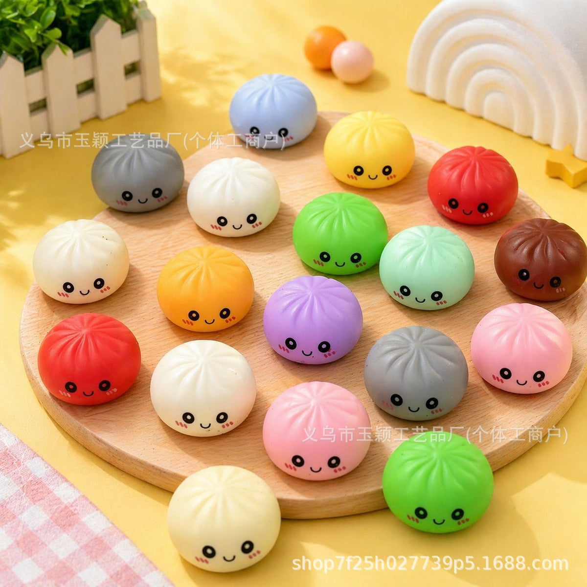 A round wooden board showcases an array of adorable, round Mystery Bun Squishies from the Okie Soft Play Mystery Bun Squishy Advent Calendar – 24-Piece Surprise Stress Relief Box. Each squishy bun features a cute smiling face and comes in vibrant shades of yellow, green, purple, and red. A petite fence in the background adds a playful accent, while the arrangement’s whimsical charm brings to mind the thoughtful balance found in expertly crafted CSS styles that elevate a product’s visual appeal.
