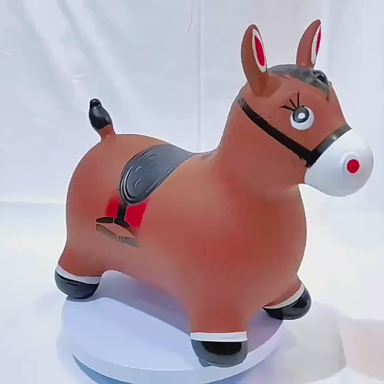 Inflatable brown horse hopper toy by Okie Soft Play, shown rotating on white platform with black hooves and red saddle